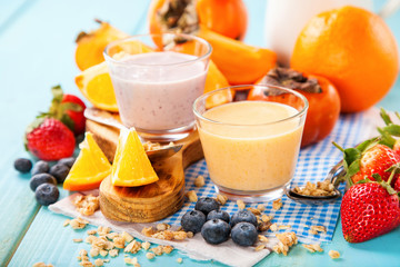 Orange persimmon blueberry smoothie with granola  and fruits. Selective focus. Copy space