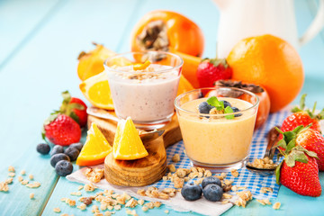 Orange persimmon blueberry smoothie with granola  and fruits. Selective focus. Copy space
