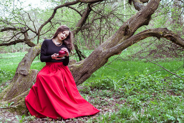 Fototapeta premium girl sitting on a tree trunk