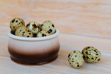  Quail eggs in ceramic bowl on wooden background. Food ingredient. Copy space