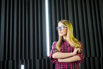 Woman in glasses with crossed hands in office building