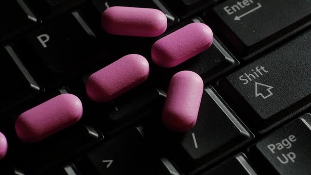 Pills medicine on keyboard - addict on a computer concept. Computer sick. Technology kills people. Slider move stops on enter key.