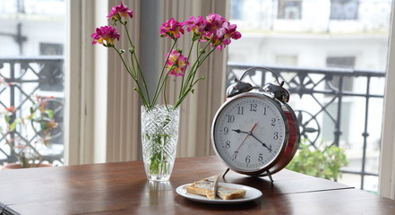 Retro clock with flowers on antique table