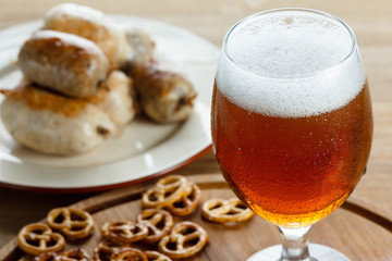Beer glass with german pretzel and sausage
