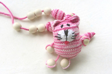 Knitted pink striped handmade crafted cat. Children's toy. Crochet pattern. Handicraft manufacturing
