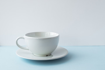 Obraz na płótnie Canvas White empty cup for coffee on the blue table