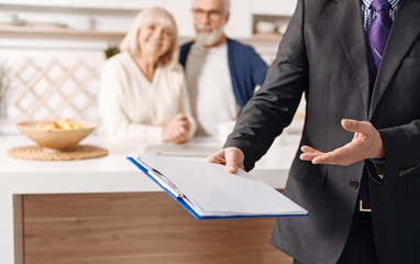 Proficient social security advisor demonstrating document for elderly couple