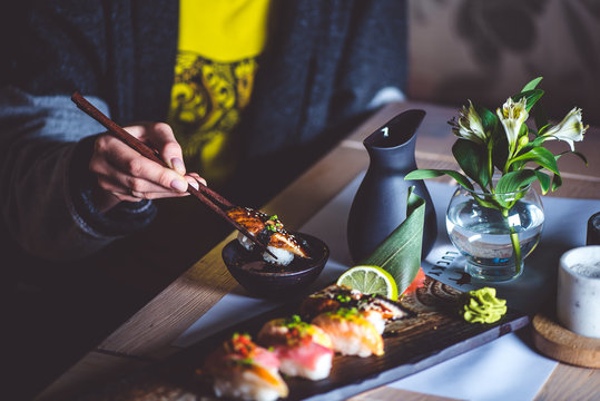 Man eating sushi set with chopsticks on restaurant