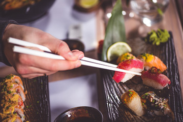Hands eat sushi with chopsticks - 140462480