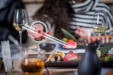 Fototapeta na wymiar Hands eat sushi with chopsticks
