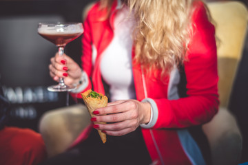 A girl holding a cocktail in her hand