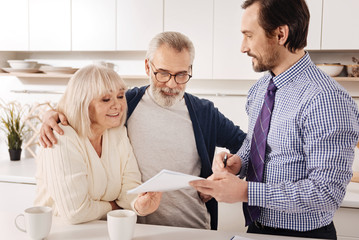 Positive aging couple owners meeting financial adviser at home