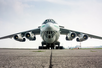 Close-up front view of big cargo airplane in a foggy airport