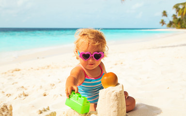 cute girl little play with sand on beach