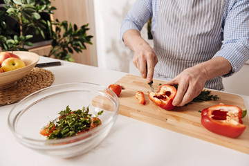 Professional cook cutting pepper for dinner in the kitchen