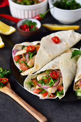 Mexican tacos with filling and guacamole sauce on a black background