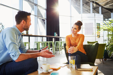 Happy colleagues, couple talking at cafe during sunny day