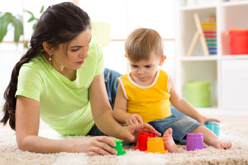 child and his mother playing together with toys