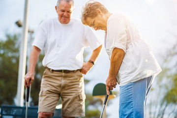 retired lifestyle of senior couple playing mini golf