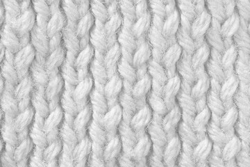 Knitted texture of white color. Hand-made knitting needles for postcard background. Winter cozy thing.