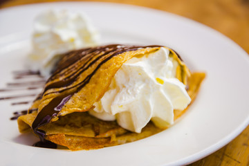 Delicious yummy crepe filled with cream and chocolate syrup topping