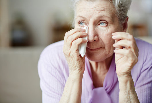 Grandmother wiping tears with tissue