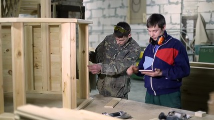 Carpenters using digital tablet in workshop - Powered by Adobe