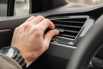 Driver hand on air ventilation grille