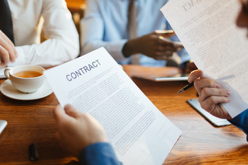 Human looking through business contracts before signing