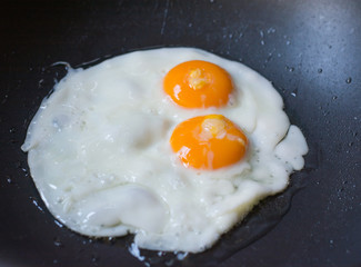 two fried eggs in a frying pan