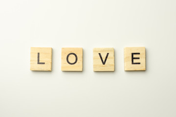 Text wooden blocks spelling the word LOVE on white background