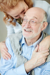 Happy life: Portrait of smiling elderly man and woman embracing caringly and cuddling looking carefree 