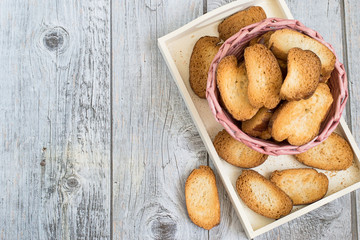   Homemade rusks.  Basket with homemade rusks on a white tray on a gray wooden table. 
