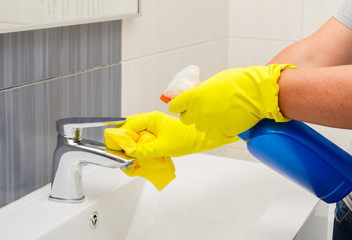 Spring cleaning, someones hands in yellow gloves washing bathroom