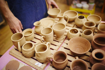 Human standing by workplace with fireclay kitchenware