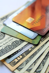 Stack of plastic bank credit cards and dollars, close-up view. Vertical business background.
