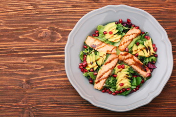 Salad with fried salmon, avocado and pomegranate seeds