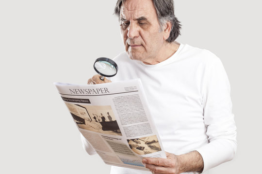 Portrait senior man reading newspaper
