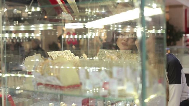 Two lovely girls at the Mall looking at the showcase with the jewelry.