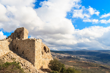 Naklejka premium Ruins of ancient Crusader fortress, Golan Heights background, beautiful sky with white clouds, Upper Galilee, Israel. Concept: travel, history and nature