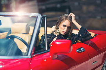 Portrait of beautiful sexy fashion woman model sitting in luxury retro cabriolet car