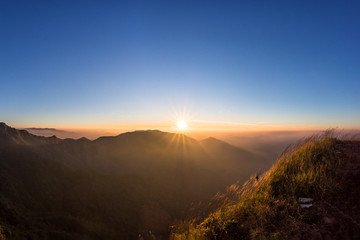 Naklejka na ściany i meble Great sunrise above the mountain valley and morning mist.