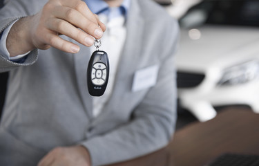 Low section of car salesman with car key.