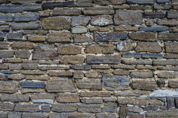 Ancient old dark regular stone wall