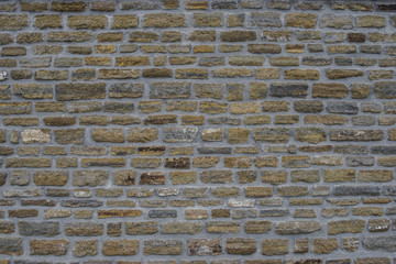 Ancient old dark regular stone wall