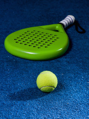 Paddle racket, next to the ball and on a carpet of the play area