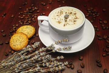 Cup of coffee with milk, pussy-willow and dried branches and leaves at brown background.