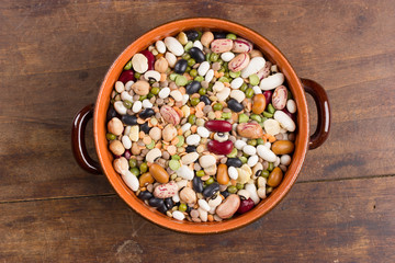Mix of colorful beans and lentils in bowl. Top view.
