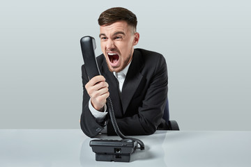 young man dials the phone number while sitting in the office