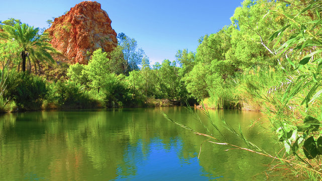 River with rock formation in background and plantations near Palm Springs campsite in halls creek, Western Australia